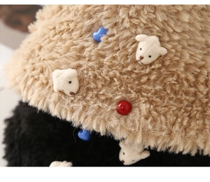 Detail of plush faux fur texture with cute bear patch and blue heart button on knit hat