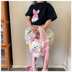 Detail of pink plush kids bag with cute 3D white bear charm and soft fuzzy texture