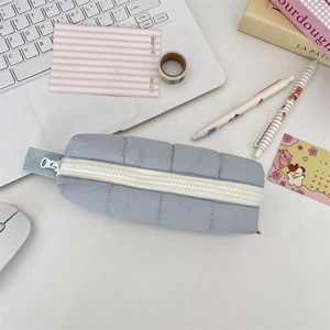 Close-up of light blue quilted pencil case with white zipper and soft nylon fabric