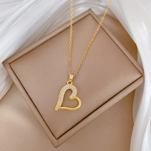 Elegant gold titanium steel heart necklace with rhinestones on silk background