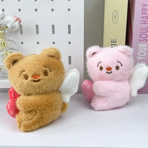 Close-up of cute plush bear charms with angel wings and hearts on a decorative shelf