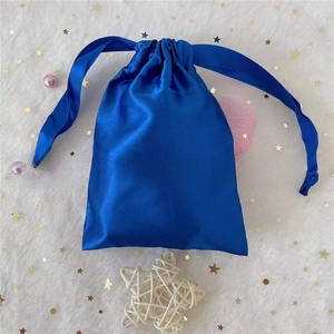 Blue satin drawstring bag with silk ribbons displayed on a star mesh background