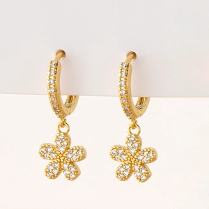 Close-up of gold flower hoop earrings with micro-paved cubic zirconia stones