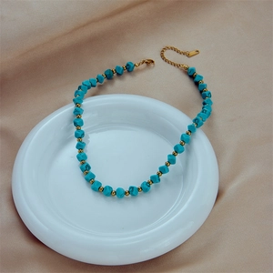 Collana bohémien in turchese con perle dorate su elegante sfondo di seta