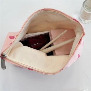 Top view of pink canvas tote showing spacious interior filled with various cosmetics