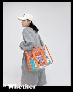 Detailed side view of a transparent PVC tote bag with vibrant orange trim on a model