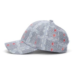 Detail view of baseball cap featuring grey rock texture and red star patterns on fabric