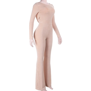 Detail view of the velvet fabric and slim fit flared hem of the beige long sleeve jumpsuit