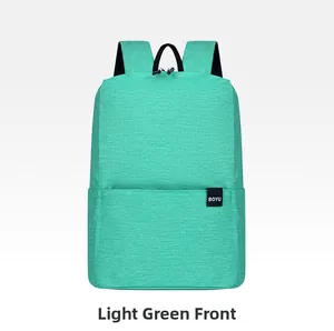 Close-up of mint green backpack featuring textured fabric and front zipper pocket detail