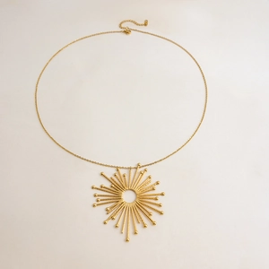 Close-up of 18K gold sunburst hollow pendant with sunray detail on stainless steel chain