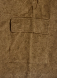 Detail of cargo flap pocket on distressed brown washed fabric with double stitching