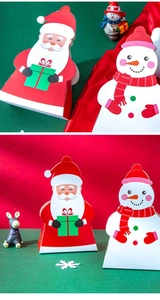 Detail view of Santa and Snowman Christmas gift boxes with festive holiday decorations