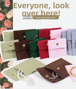 Vue macro d'une pochette à bijoux en velours avec bouton pression pour colliers