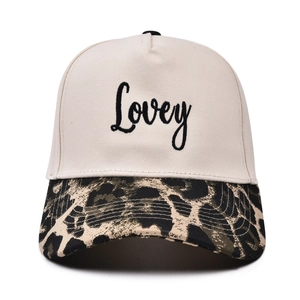 Close-up of Lovey script embroidery on cream and leopard print five-panel baseball cap