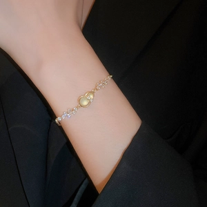 Close-up of a gold zircon gourd bracelet with cat-eye stone on a woman's wrist
