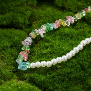 Hip hop beaded necklace featuring colorful gravel stones and white pearls on green moss