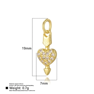 Macro shot of 18K gold plated heart and arrow pendant with cubic zirconia inlay details