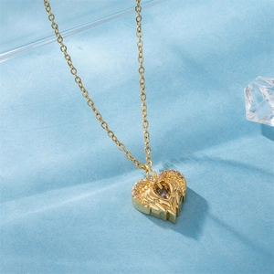 Golden necklace with heart-shaped angel wings pendant and inlaid zircon on blue background