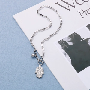 Detail of silver paperclip chain necklace with Hamsa Hand pendant and toggle clasp