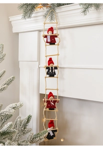 Hanging Santa climbing ladder ornament on white fireplace with cedar branches