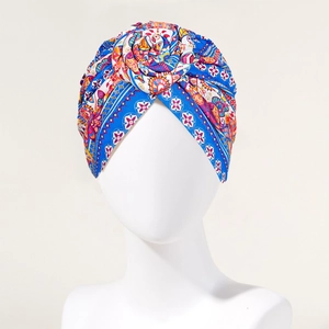 Detail of bohemian turban featuring colorful paisley print and 3D floral knot design