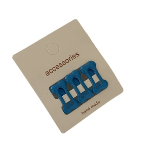 Three-piece set of blue bone-shaped hair clips with polka dots on a white card