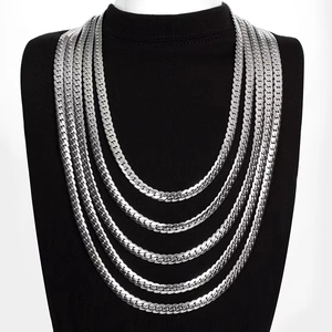 Polished silver stainless steel Cuban link chains in various sizes on a black bust