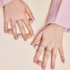 Detailed close-up of rainbow cubic zirconia S925 sterling silver rings on model hand