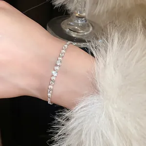 Elegant zircon and pearl link bracelet on wrist with a luxury aesthetic style