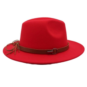 Detail of red fedora hat featuring a brown leather belt with metal ring and fringe tassel