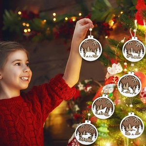 Detailed view of carved wooden Christmas animal ornaments held by a hand near a tree
