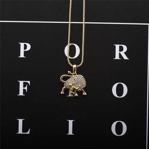 Detail of a gold Taurus bull pendant with sparkling zircons against a black background