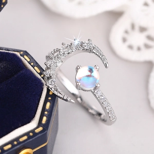 Macro shot of silver moon ring with iridescent stone and micro-pave crystals