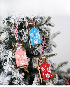 Detail of wooden Christmas sled ornaments with snowflake patterns on festive tree branches