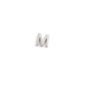 Close-up of a 3D silver vintage stainless steel letter M pendant for DIY jewelry
