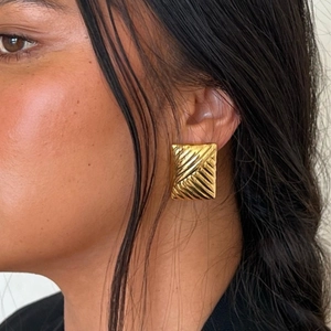 Golden rectangular earrings with diagonal texture worn by model for vintage aesthetic