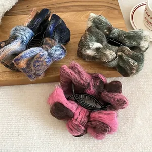 Three elegant plush bow hair clips in mixed winter colors displayed on wooden tray