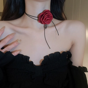 Close-up of a handmade red fabric rose choker on a thin black cord for women