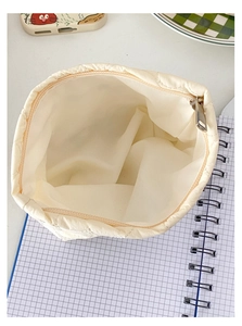 Dettaglio interno della borsa trapuntata beige con fodera morbida e cerniera in metallo