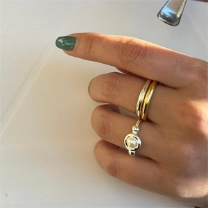 Close-up of 925 silver pearl ring set with gold and silver bands on female hand