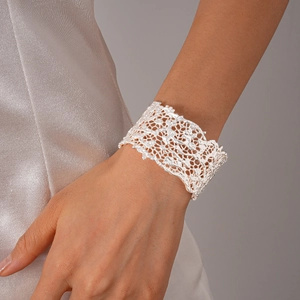 Detailed macro view of wide open cuff bracelet with intricate lace texture in bright silver