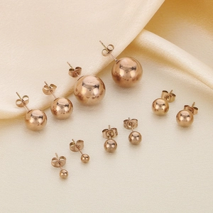 Set of five pairs of polished gold ball stud earrings in varying sizes on silk fabric