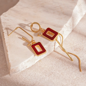 Retro geometric earrings with red acrylic accents and long gold metal tassels