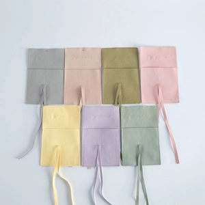 Detailed view of microfiber jewelry pouches in various pastel colors with ribbons