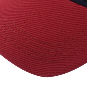 Close-up of red twill cotton fabric with parallel stitching details on a baseball cap brim