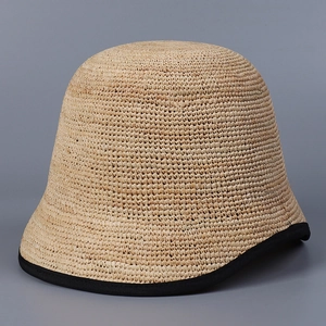Minimalist raffia bucket hat for women with black fabric trim and natural straw weave