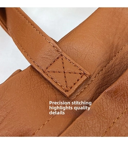 Detail view of precise stitching and pebble grain texture on brown PU leather tote bag