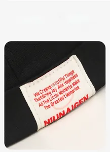 Macro detail of the woven label with red embroidery on a black cotton skull cap