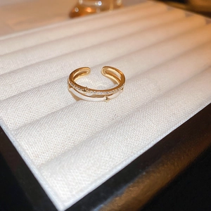Detail of gold-plated dragon ring with white enamel and sparkling zircon accents