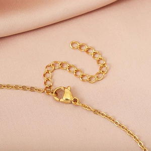 Detailed close-up of the gold chain necklace featuring lobster clasp and extension chain